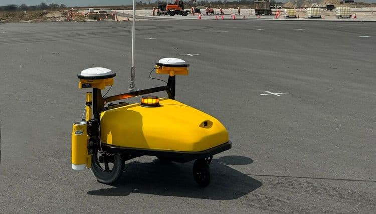 CivDot Mini robot performing fast layout for parking lot striping and road marking on construction site.